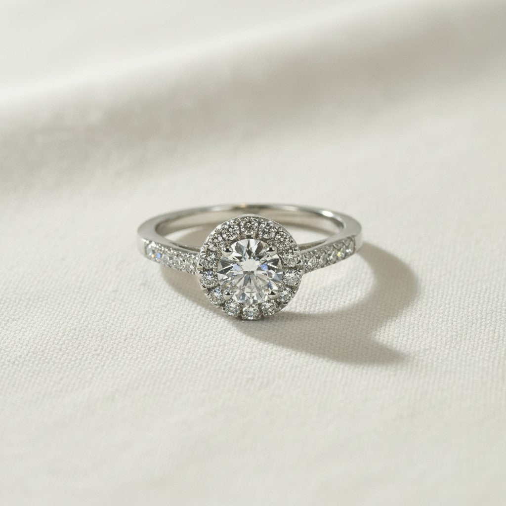 Anillo de platino Sophia Schneider Joyas con diamante central brillante de 0,50 ct y halo de diamantes pequeños, engastado en grifa.
