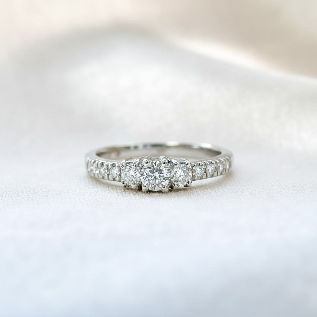 Anillo de platino Sophia Schneider Joyas con tres diamantes centrales de corte brillante y diamantes laterales engastados en la banda.