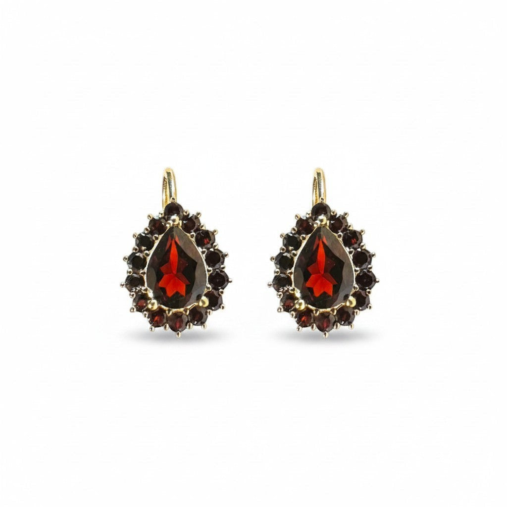 Sophia Schneider Joyas 14K gold dangle earrings with pear-cut garnet center and surrounding smaller garnets.