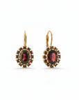 Sophia Schneider Joyas oval 14K gold dangle earrings with central oval garnet surrounded by halo of small garnets.