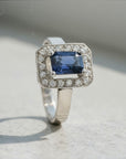 Sophia Schneider Joyas platinum halo ring with emerald-cut sapphire and 0.18 ct diamonds.