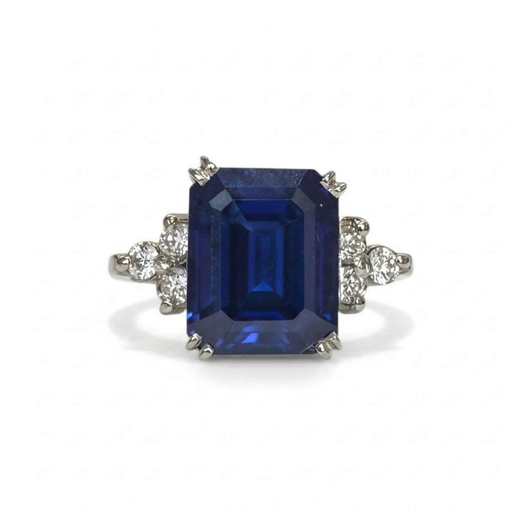 Sophia Schneider Joyas platinum ring with emerald-cut sapphire and surrounding diamonds.