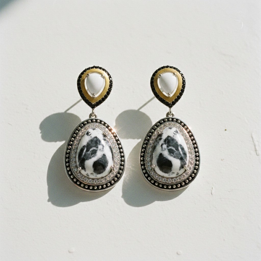 Sophia Schneider Joyas teardrop earrings with white and black stone, silver, gold, and black accents.