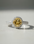 Sophia Schneider Joyas silver ring with a round yellow citrine/topaz center stone surrounded by small clear stones.