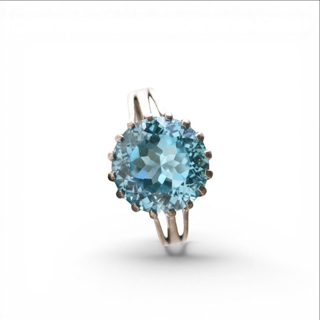 Sophia Schneider Joyas silver ring with a large, round, faceted sky blue topaz gemstone.